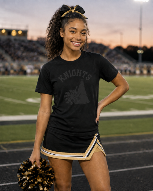 Cheerleader wearing a black on black cheer T-shirt at a football stadium