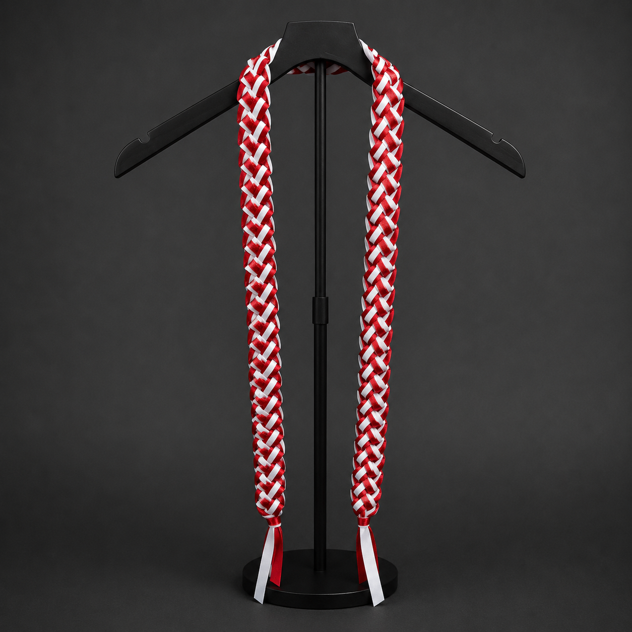 3 strand Red and white personalized Ribbon Lei with glitter on a black stand against a dark background